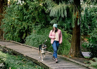 Dog trainer walking through a trail with a dog